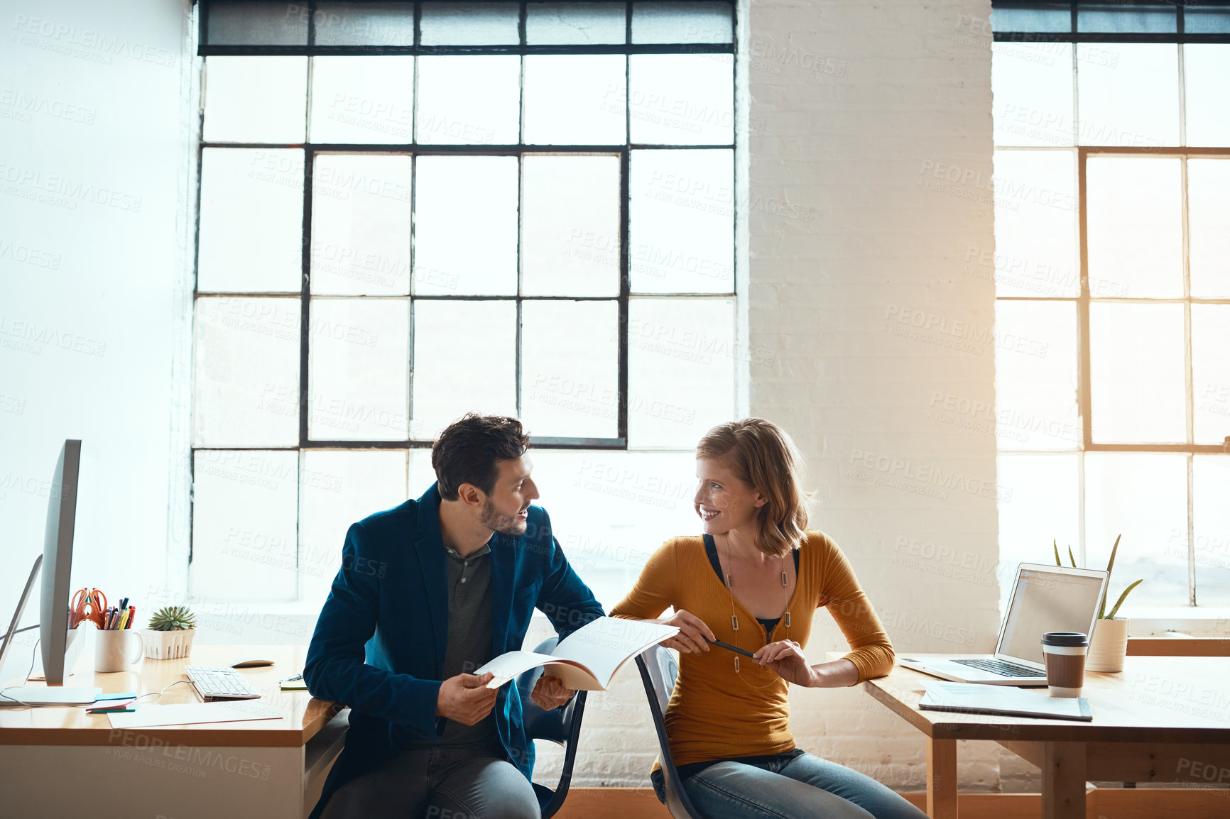 Buy stock photo Cropped shot of two young businesspeople working together in a modern office