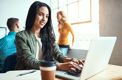 Buy stock photo Cropped shot of an attractive young businesswoman working in a modern office with her colleagues in the background