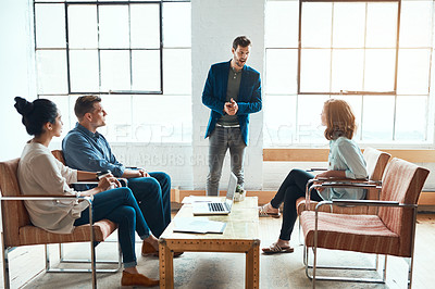 Buy stock photo Shot of a group of young businesspeople having a meeting in a modern office