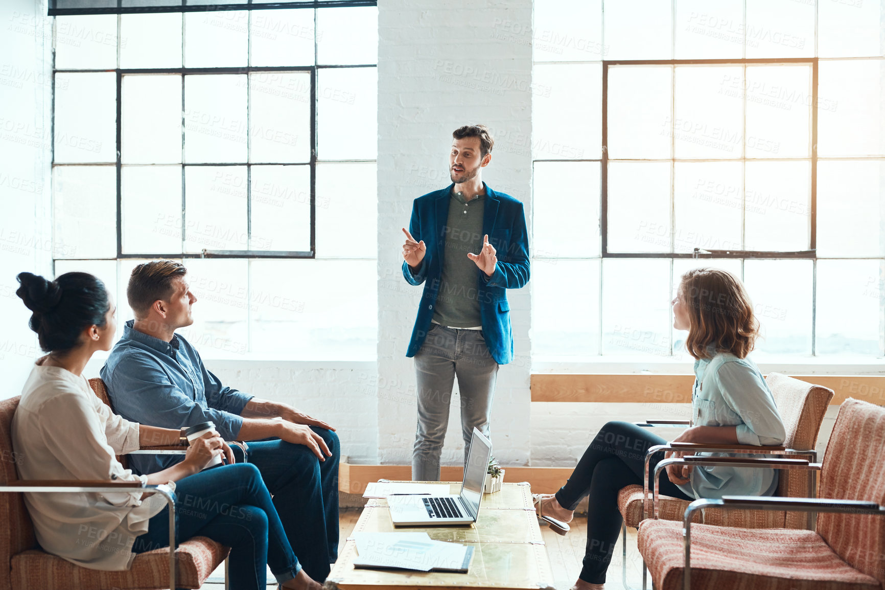 Buy stock photo Shot of a group of young businesspeople having a meeting in a modern office