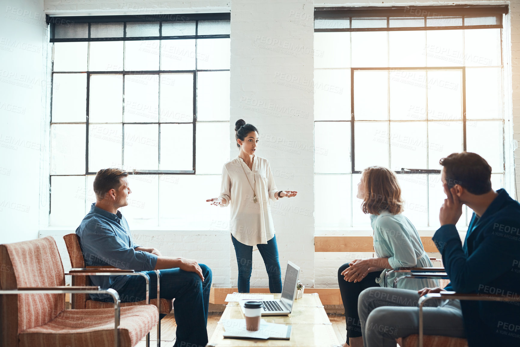 Buy stock photo Shot of a group of young businesspeople having a meeting in a modern office