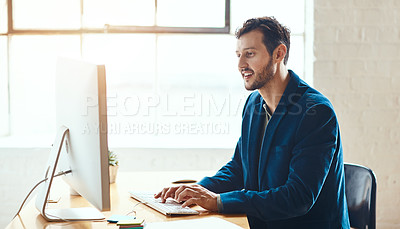 Buy stock photo Cropped shot of a handsome young businessman working on his computer in a modern office