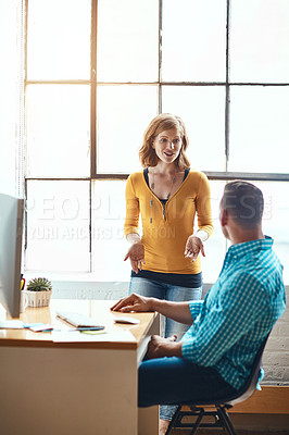 Buy stock photo Cropped shot of an attractive young businesswoman giving some advice to a male colleague while working in a modern office