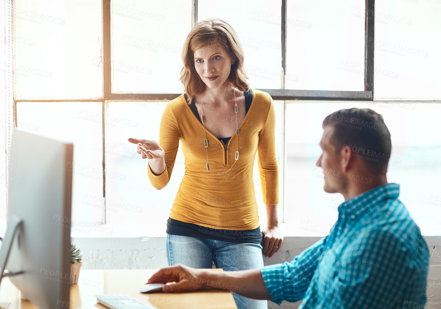 Buy stock photo Cropped shot of an attractive young businesswoman giving some advice to a male colleague while working in a modern office