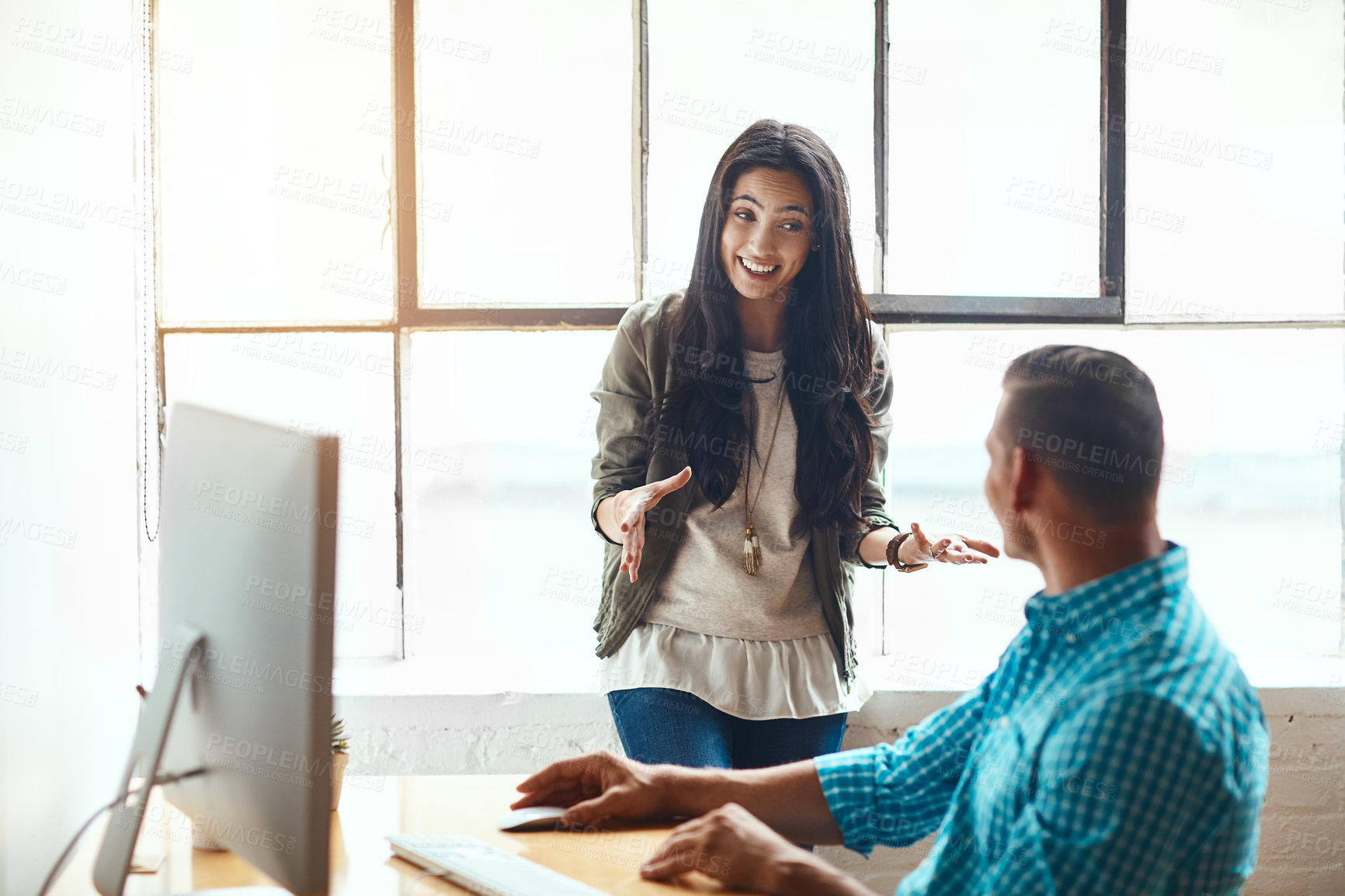 Buy stock photo Cropped shot of an attractive young businesswoman giving some advice to a male colleague while working in a modern office