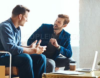 Buy stock photo Cropped shot of two young businessmen working on a laptop together in their modern office