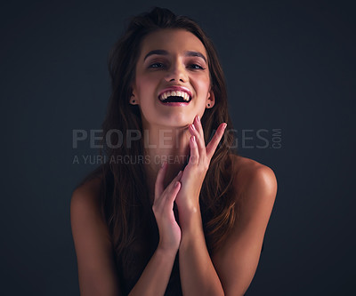 Buy stock photo Studio shot of an attractive young woman posing against a dark background