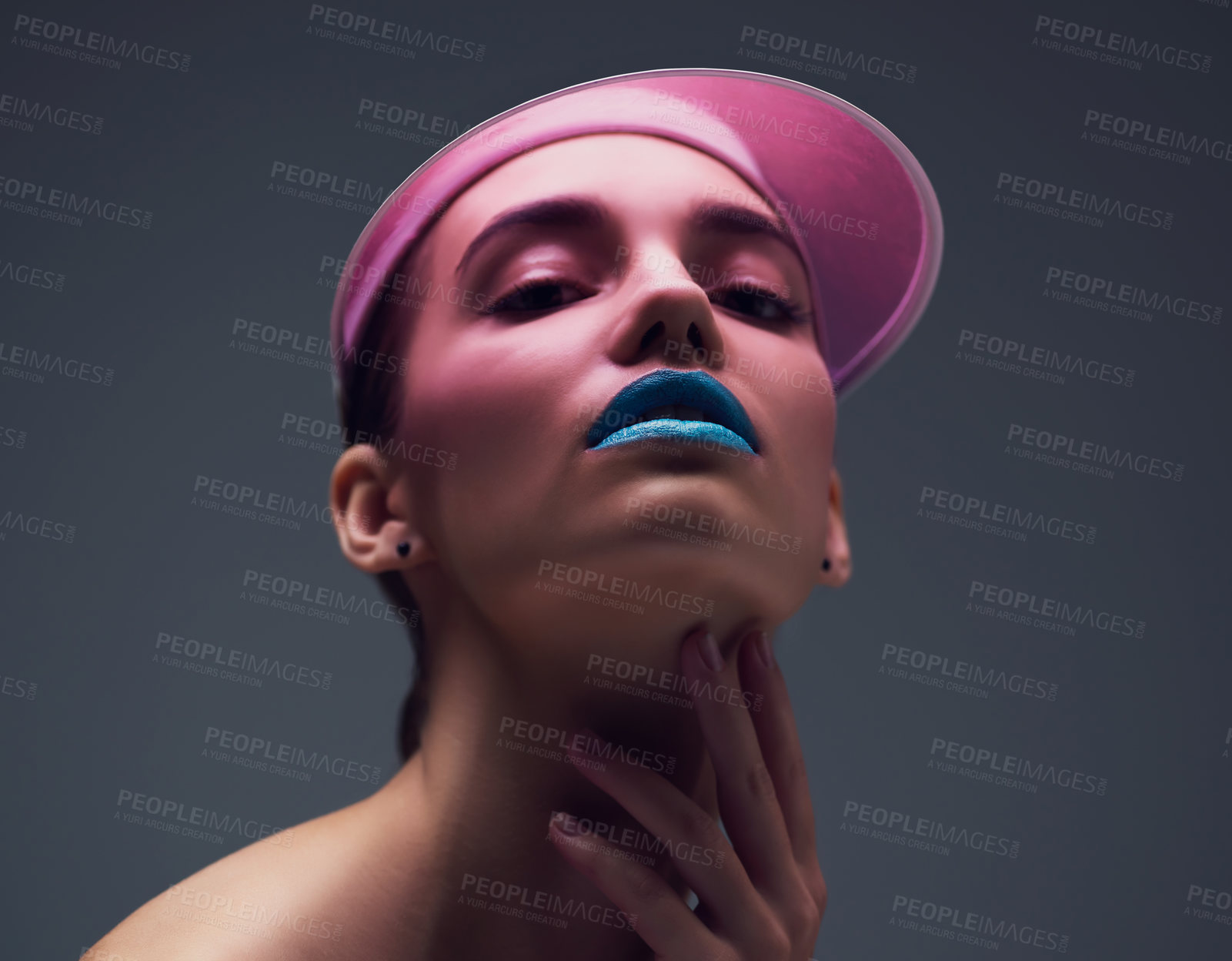 Buy stock photo Studio shot of an attractive young woman wearing a pink retro cap posing against a gray background