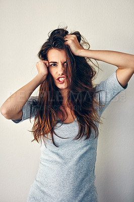 Buy stock photo Studio shot of an attractive young woman posing with her hands in her hair
