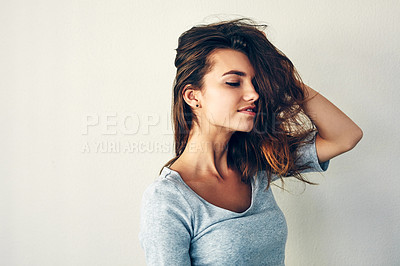 Buy stock photo Studio shot of an attractive young woman posing with her hand in her hair