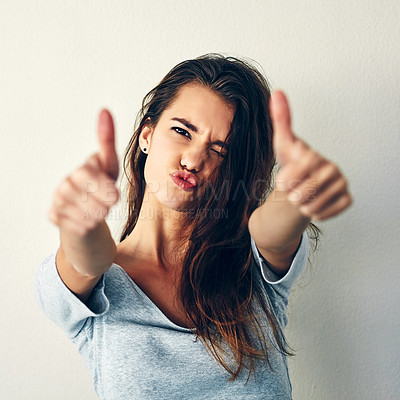 Buy stock photo Studio shot of an attractive young woman showing thumbs up