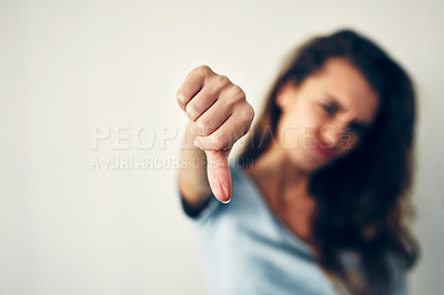Buy stock photo Cropped shot of a young woman showing thumbs down