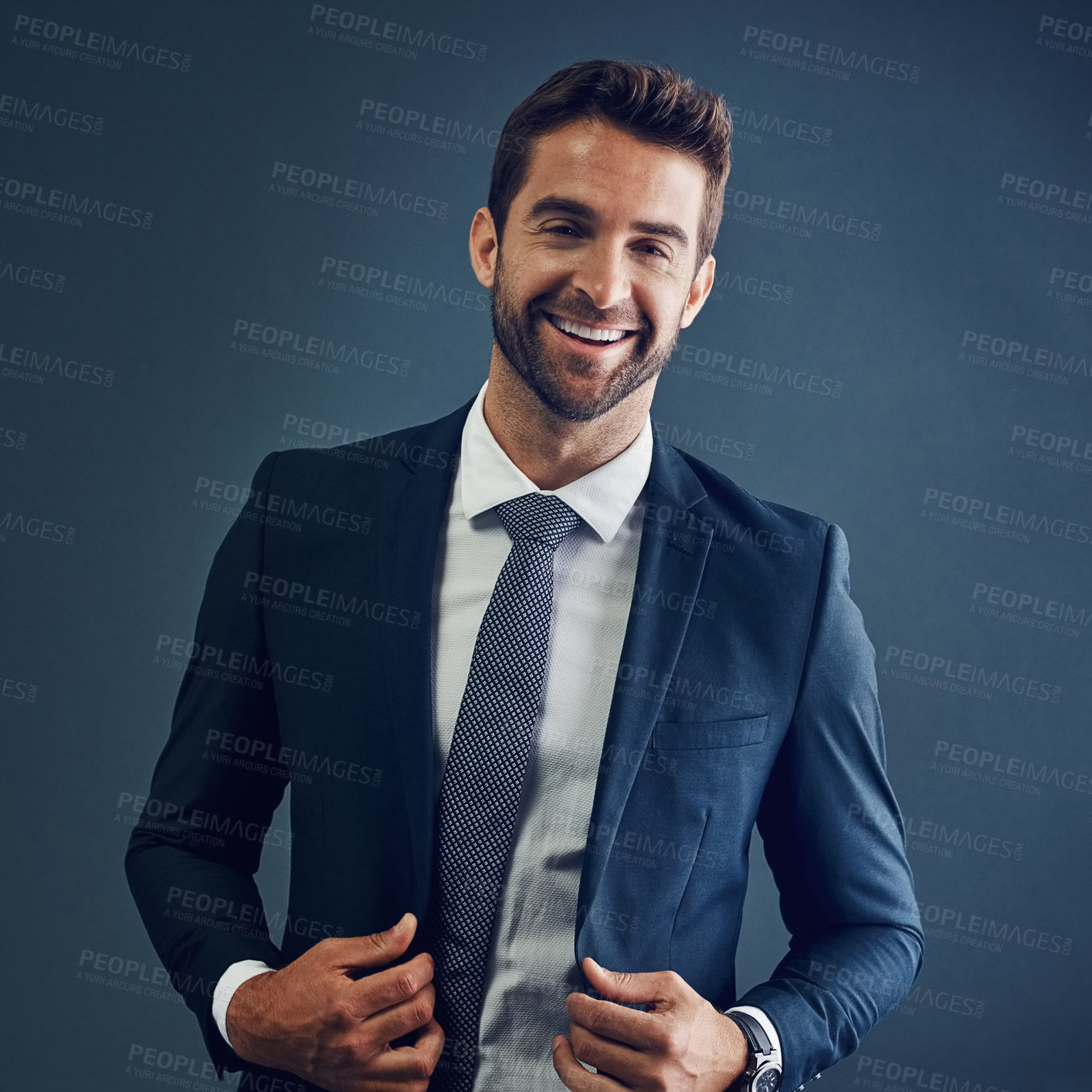 Buy stock photo Studio portrait of a handsome young businessman posing against a dark background