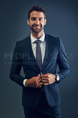 Buy stock photo Studio portrait of a handsome young businessman posing against a dark background