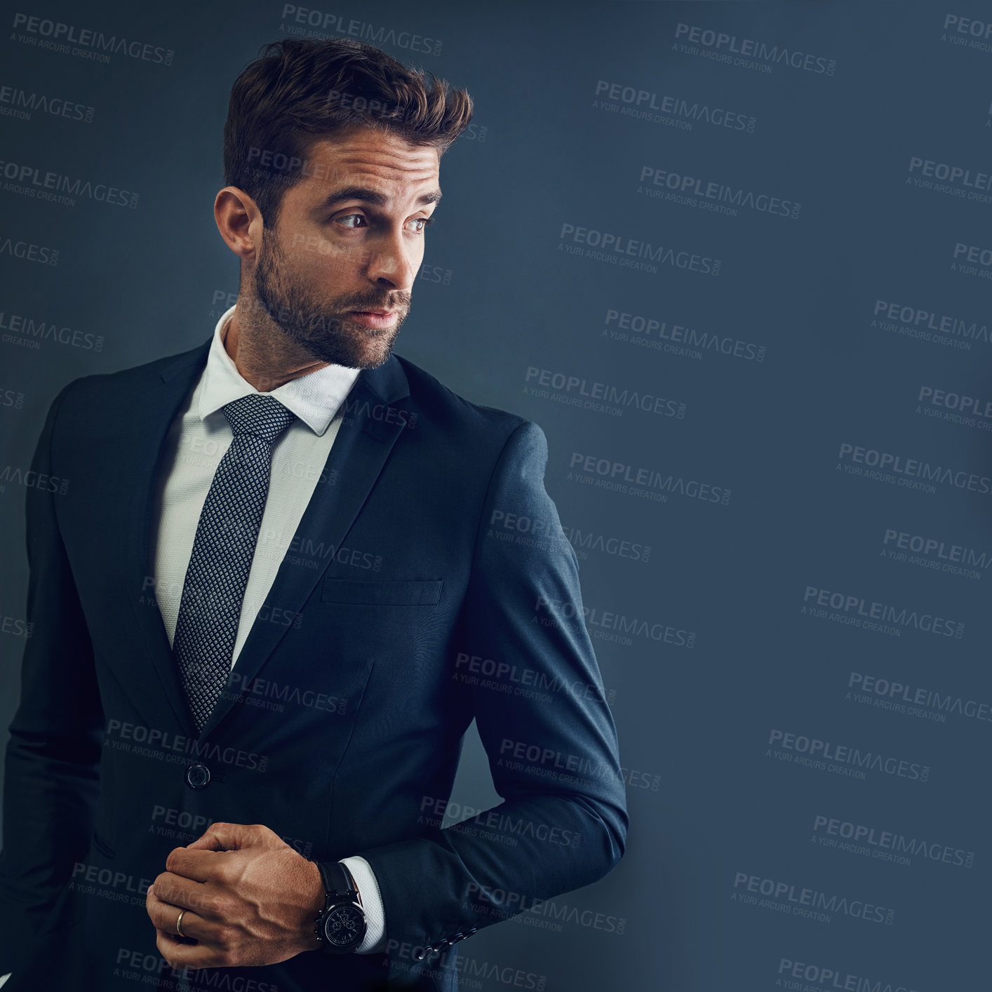 Buy stock photo Studio shot of a handsome young businessman posing against a dark background