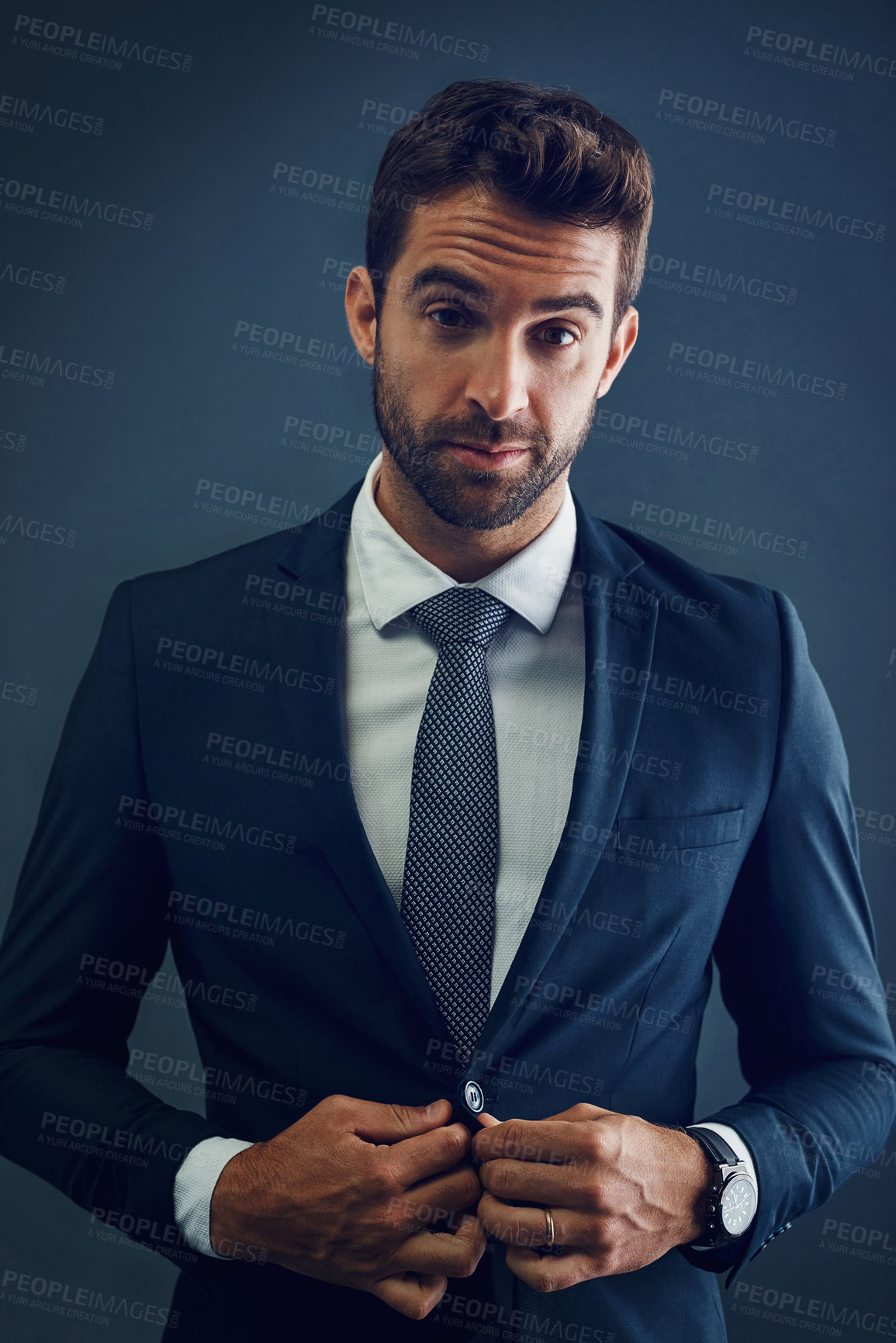 Buy stock photo Studio portrait of a handsome young businessman posing against a dark background