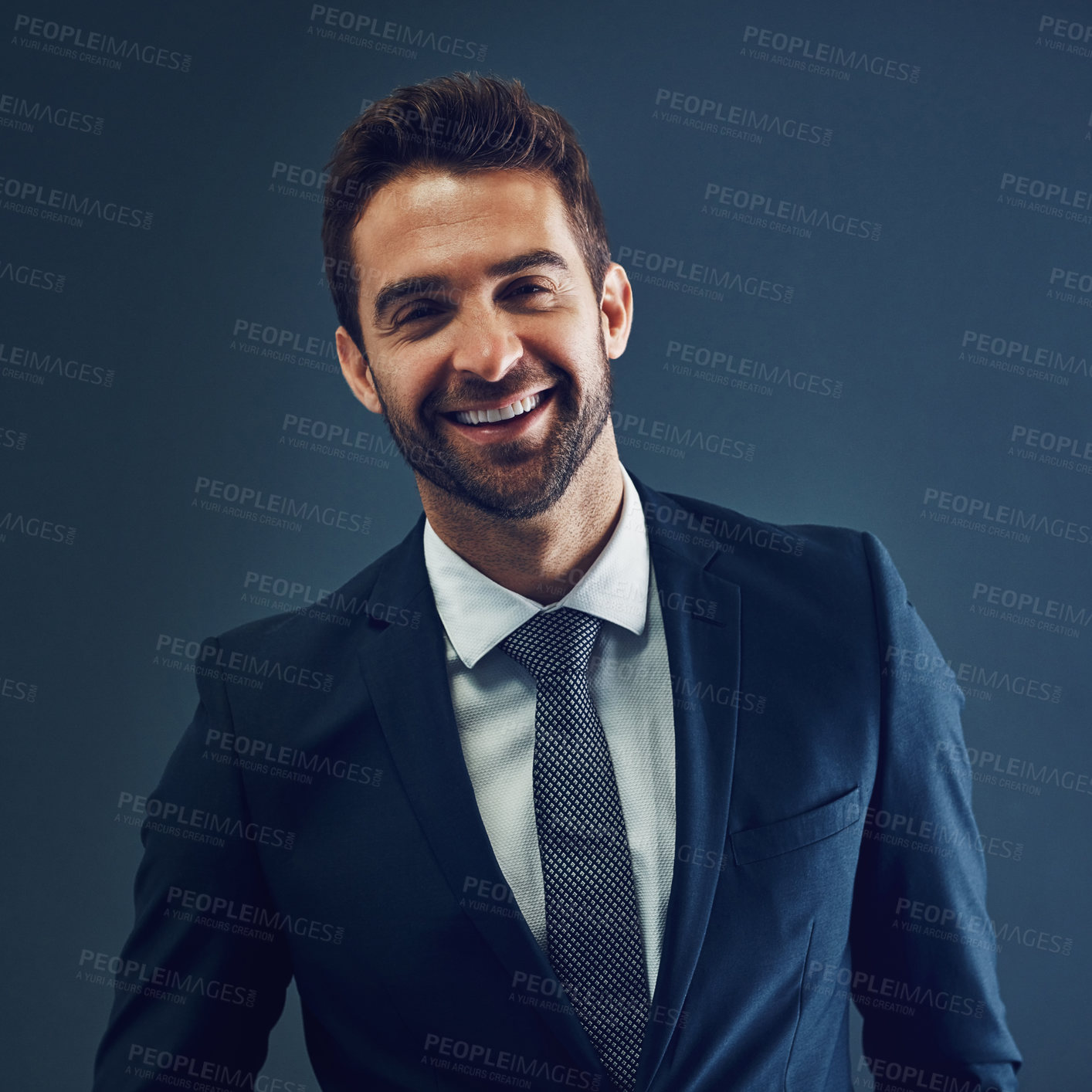 Buy stock photo Studio portrait of a handsome young businessman posing against a dark background