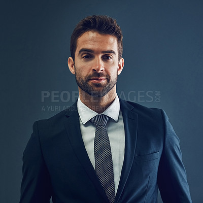 Buy stock photo Studio portrait of a handsome young businessman posing against a dark background