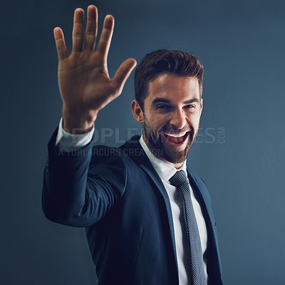 Buy stock photo Studio portrait of a handsome young businessman gesturing for a high five against a dark background