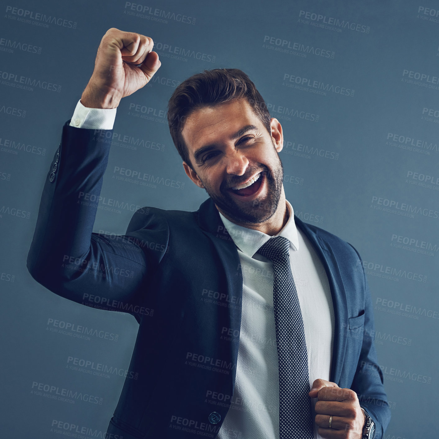 Buy stock photo Studio portrait of a handsome young businessman cheering against a dark background