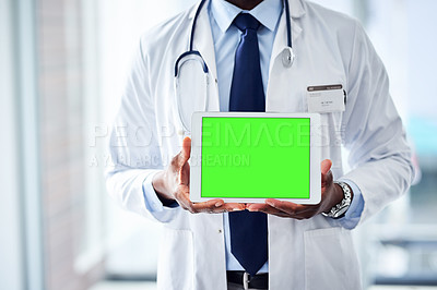 Buy stock photo Shot of a unrecognizable doctor holding a digital tablet while standing inside of a hospital during the day
