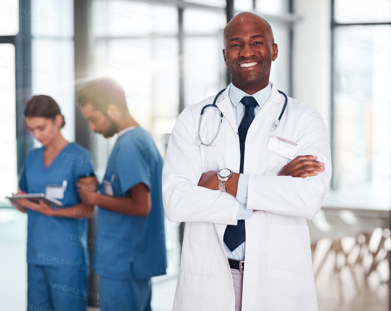 Buy stock photo Leader, doctor and portrait of person in hospital, healthcare or clinic with medical expert nurses to trust in quality care. Black man, medicine and happy brain surgeon, arms crossed and confidence