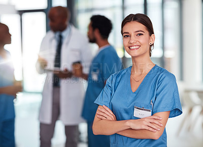 Buy stock photo Portrait of a cheerful young doctor standing with her arms folded inside of a hospital during the day