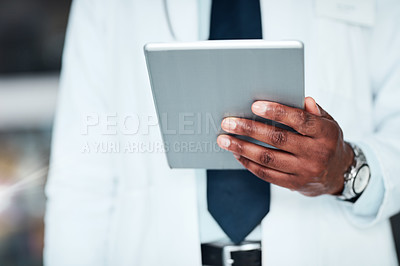 Buy stock photo Shot of an unrecognizable doctor's hand holding a digital tablet while standing inside of a hospital during the day