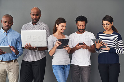 Buy stock photo Studio shot of businesspeople using wireless technology against a gray background