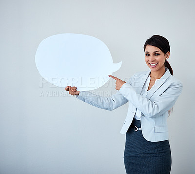 Buy stock photo Studio shot of an attractive corporate businesswoman holding up a speech bubble against a gray background