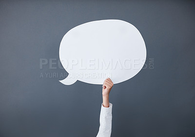 Buy stock photo Studio shot of an unrecognizable businesswoman holding up a white speech bubble against a gray background