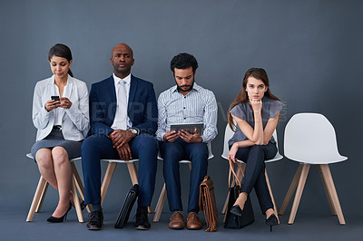 Buy stock photo Studio shot of a group of corporate businesspeople waiting in line against a gray background