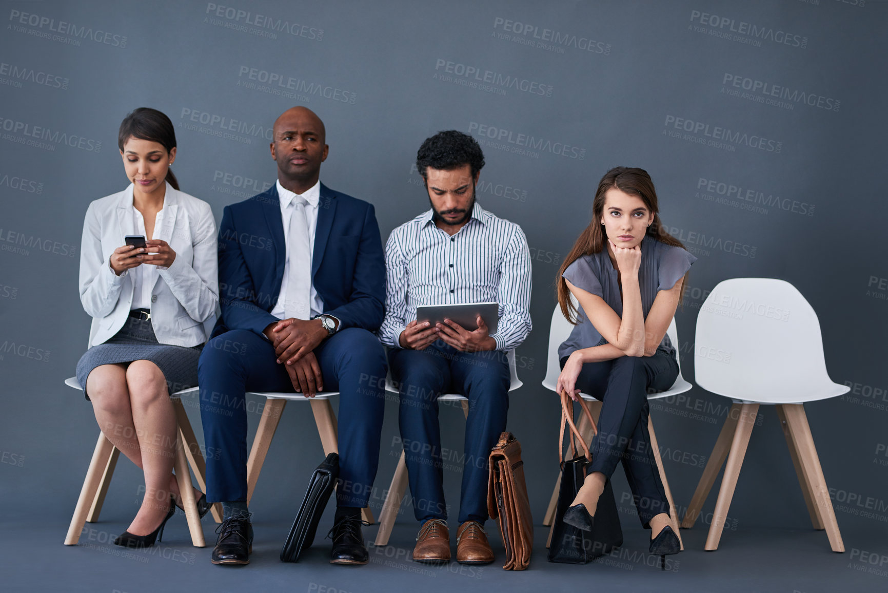 Buy stock photo Studio shot of a group of corporate businesspeople waiting in line against a gray background