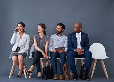 Buy stock photo Studio shot of a group of corporate businesspeople waiting in line against a gray background