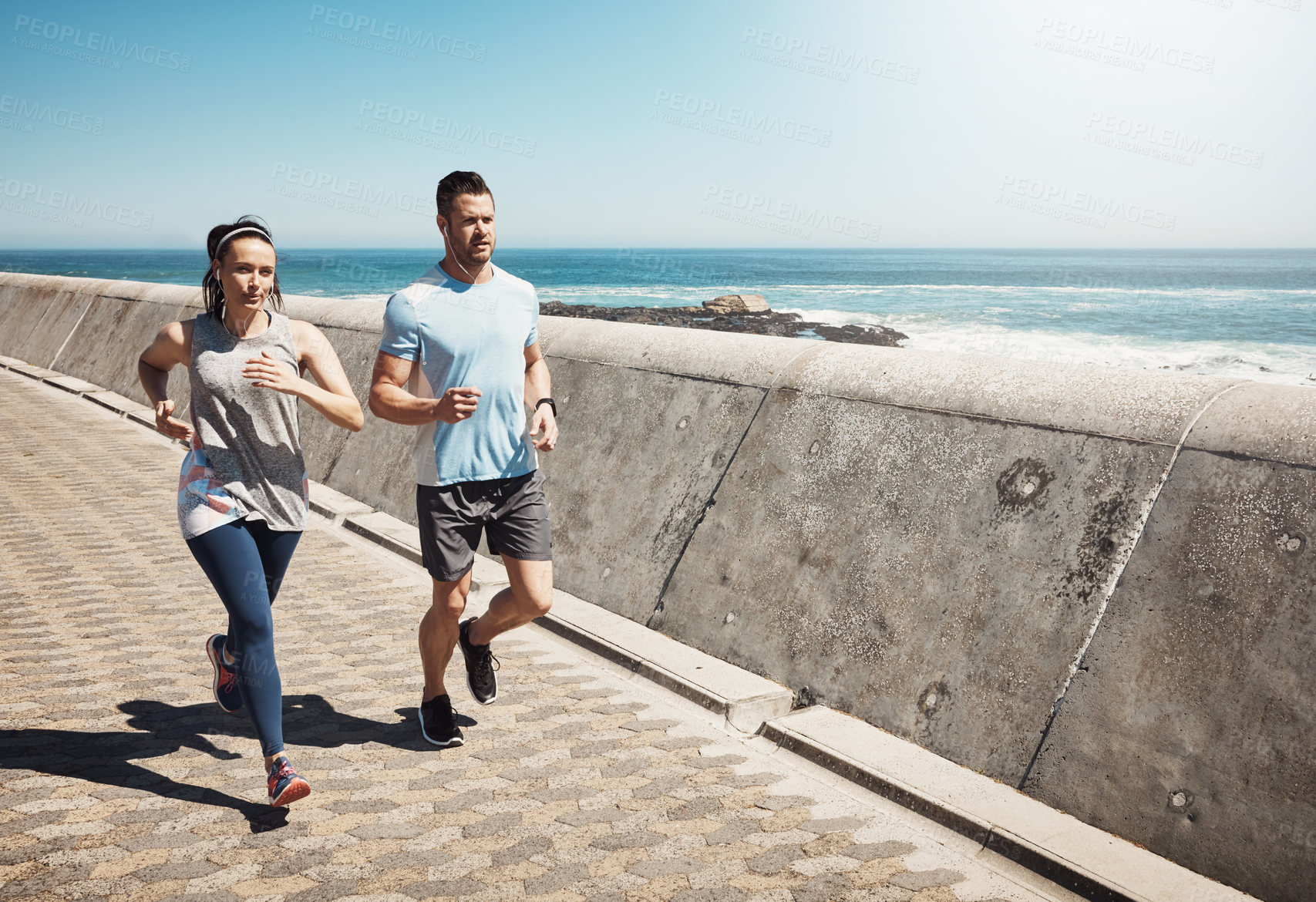 Buy stock photo Running, sports and couple by sea for fitness listening to music, audio and radio for workout. Health, wellness and man and woman outdoors for exercise, marathon training and cardio by ocean together