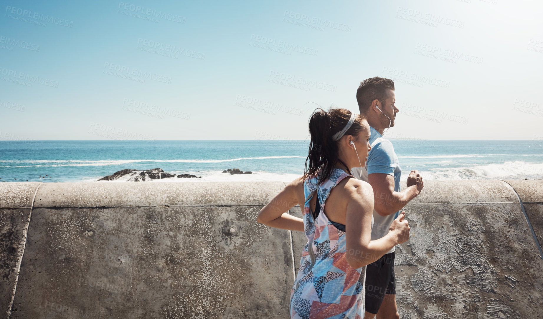 Buy stock photo Cropped shot of a young couple out for a run on the promenade