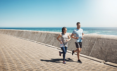 Buy stock photo Full length shot of a young couple out for a run on the promenade