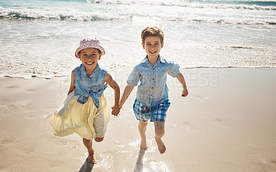 Buy stock photo Shot of two adorable young children running hand-in-hand on the beach