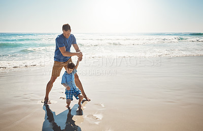 Buy stock photo Shot of a father and his little son bonding together at the beach
