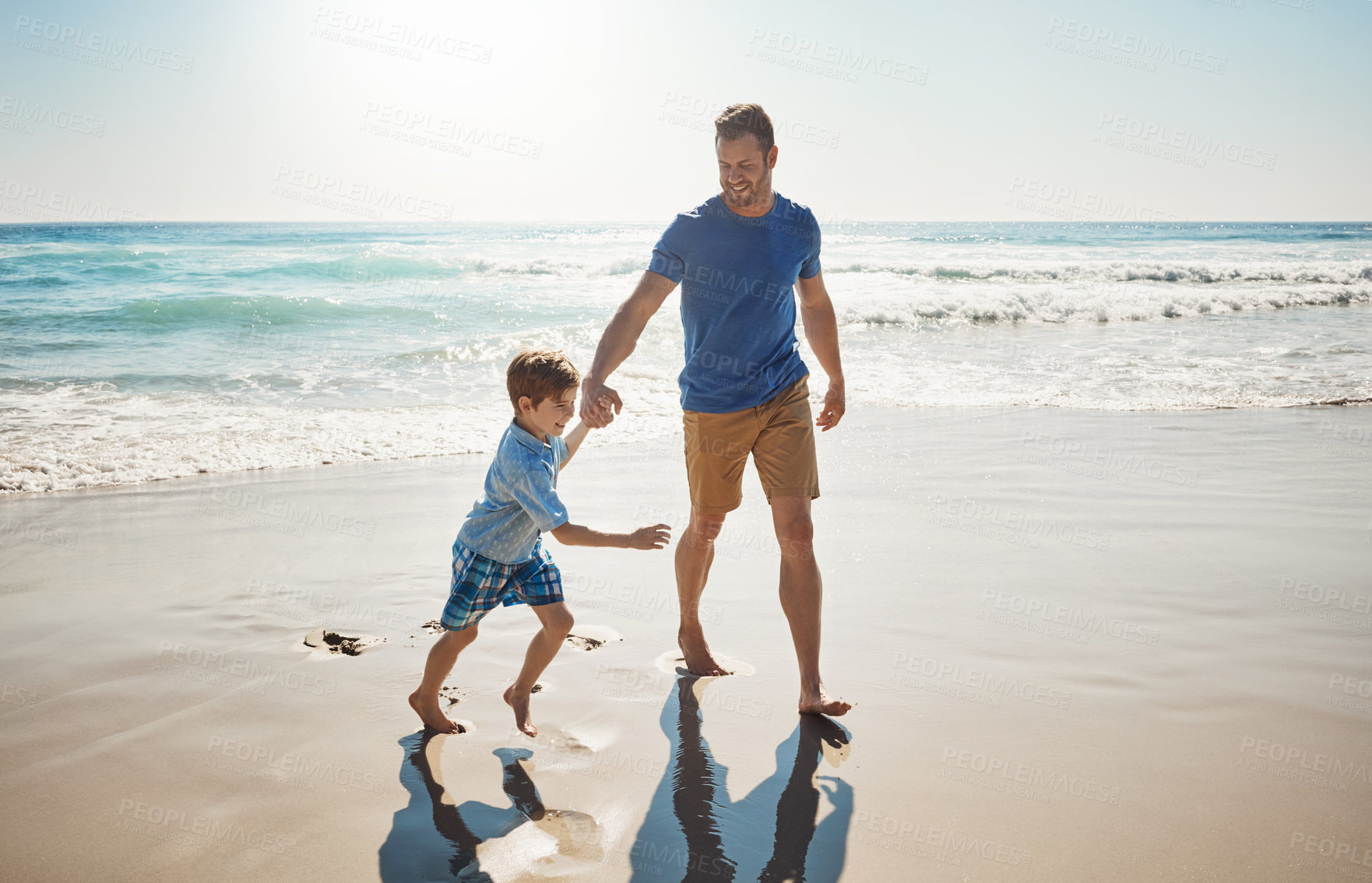 Buy stock photo Shot of a father and his little son bonding together at the beach