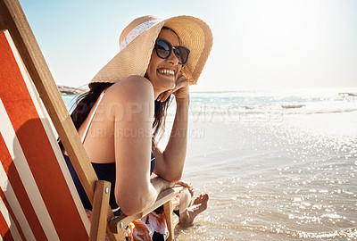 Buy stock photo Shot of an attractive young woman relaxing on chair at the beach