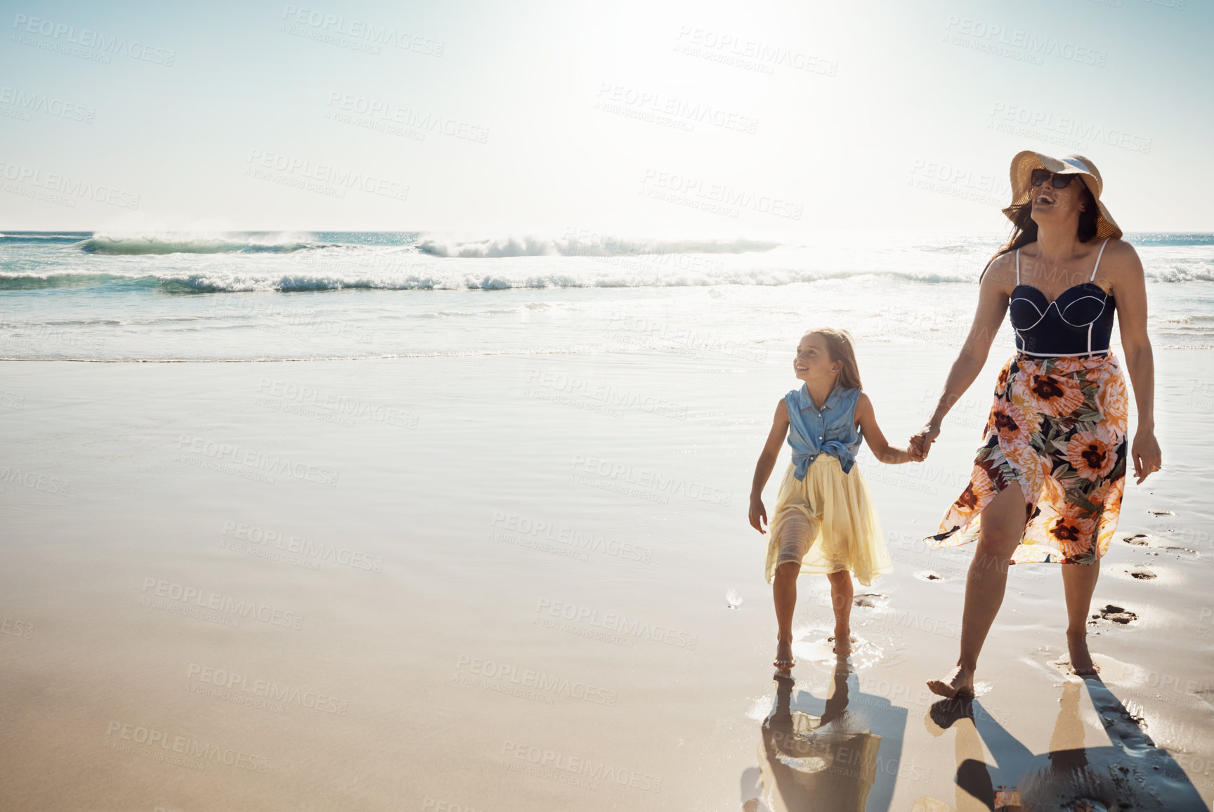 Buy stock photo Shot of a mother and her little daughter bonding together at the beach