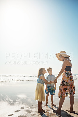 Buy stock photo Shot of a mother bonding with her two little children at the beach