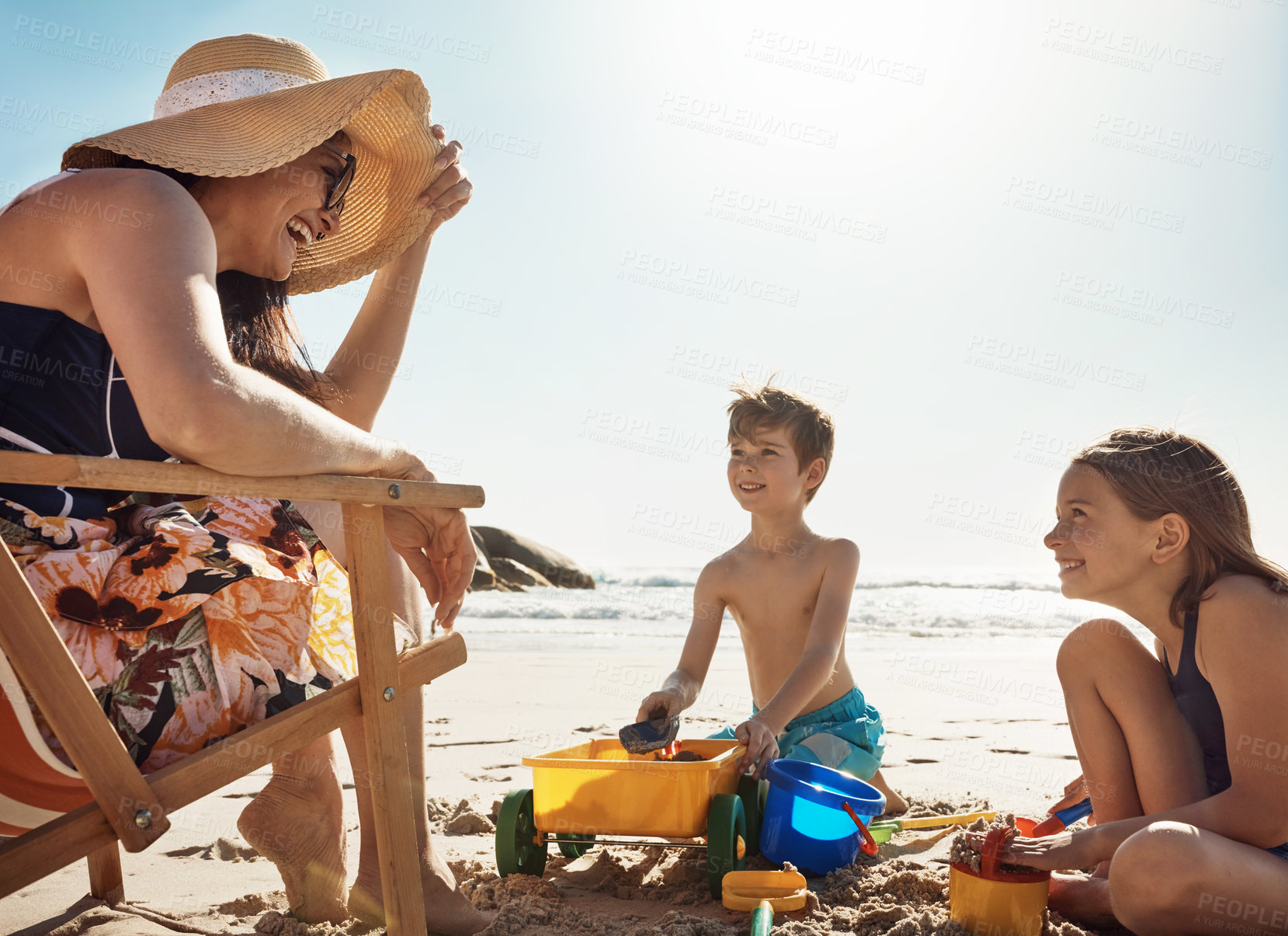 Buy stock photo Mother, children and castle at beach, vacation and happy in summer, playful and container for bonding. Mom, boy and girl with family, holiday and sand with bucket, sunshine and sea with mockup space