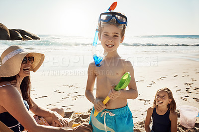 Buy stock photo Shot of an adorable little boy wearing snorkelling goggles on a fun day with family at the beach