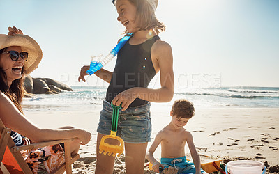 Buy stock photo Mother, children and vacation at beach, happy and relax in summer, playful and container with bonding. Mom, boy and girl in family, holiday and toys with bucket, sunshine and sea with love for games