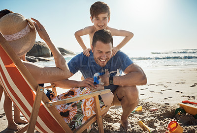 Buy stock photo Shot of an adorable little boy having fun with his mother and father at the beach