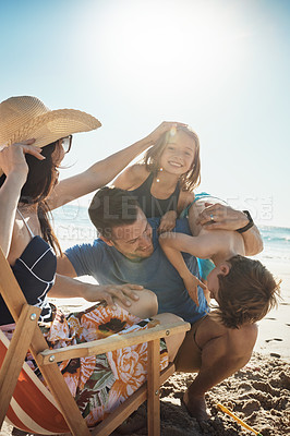 Buy stock photo Shot of a happy family of four having fun at the beach