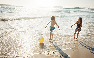 Buy stock photo Shot of a little brother and sister playing together on the beach