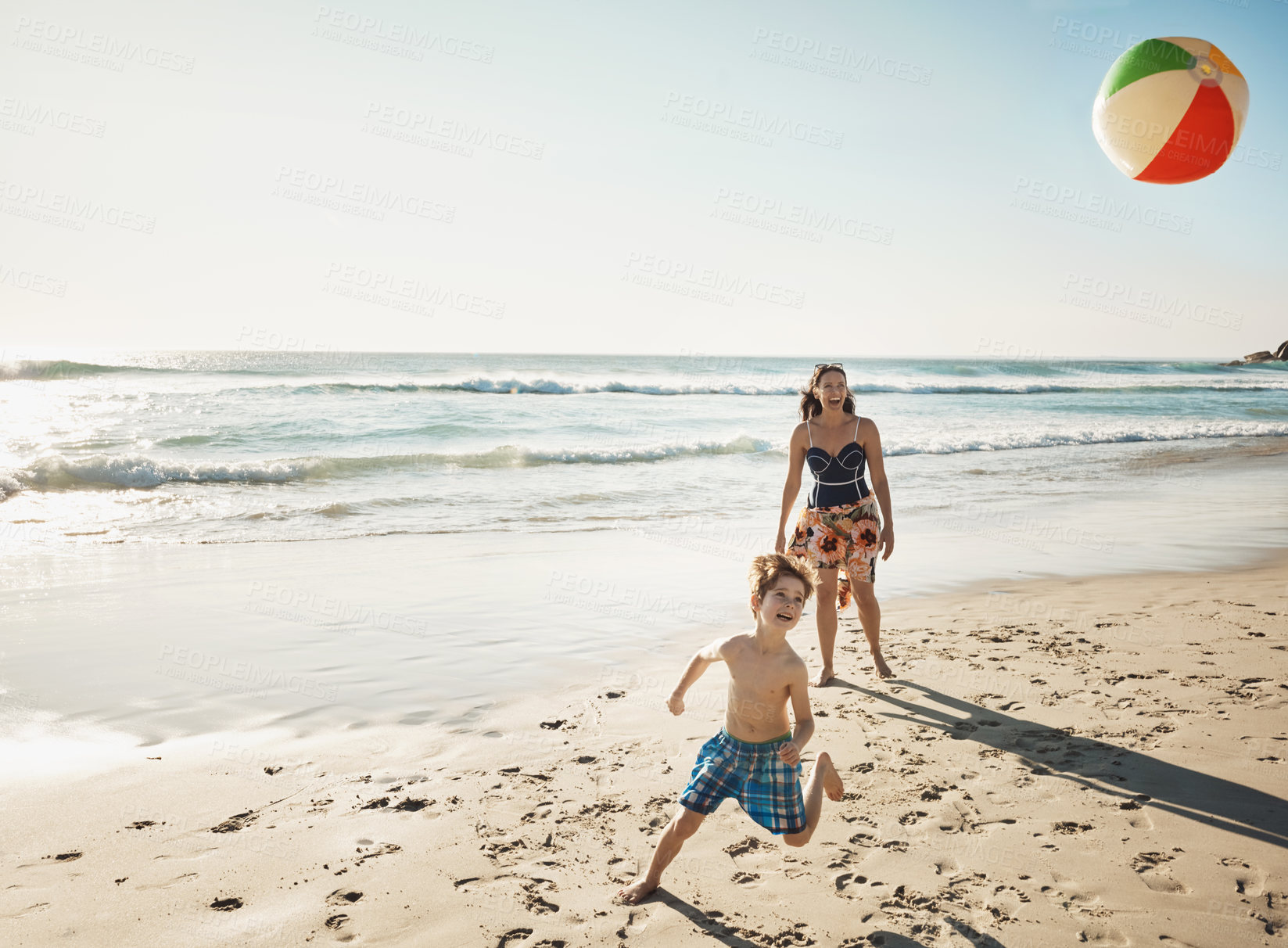 Buy stock photo Shot of a young woman spending the day at the beach with her son